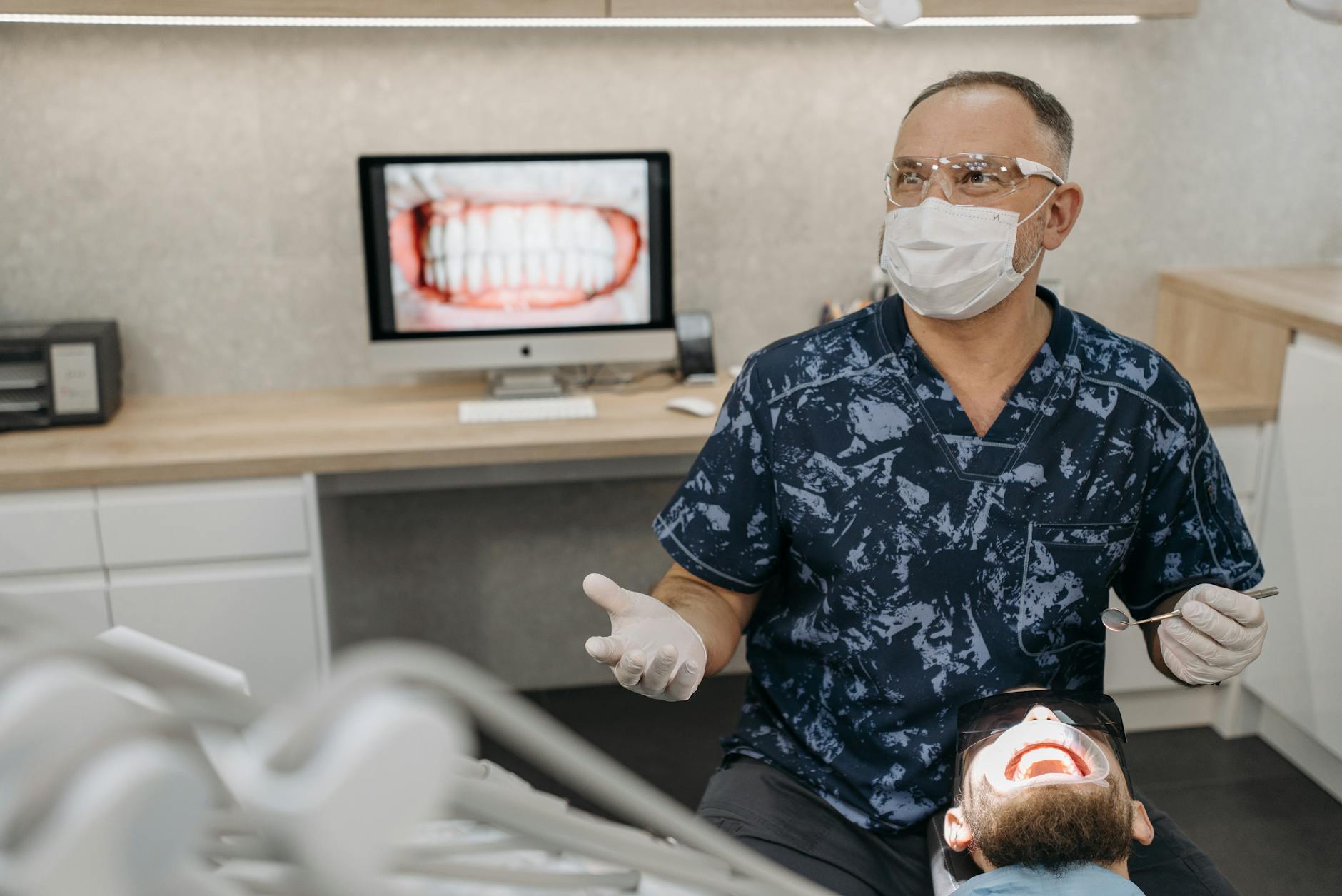 Dentist speaking with a patient in a well-lit office